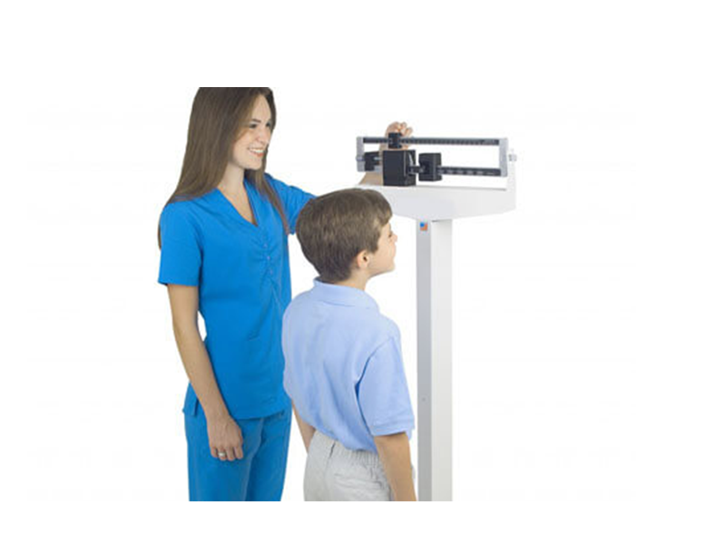 nurse weighing child on scale