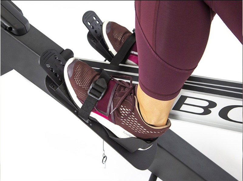 womans feet on pedals of Bodycraft Pro Air Rowing Machine