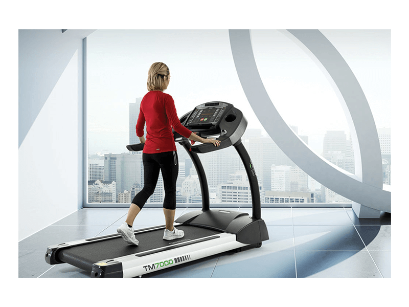 Woman using Circle Fitness M7e Treadmill