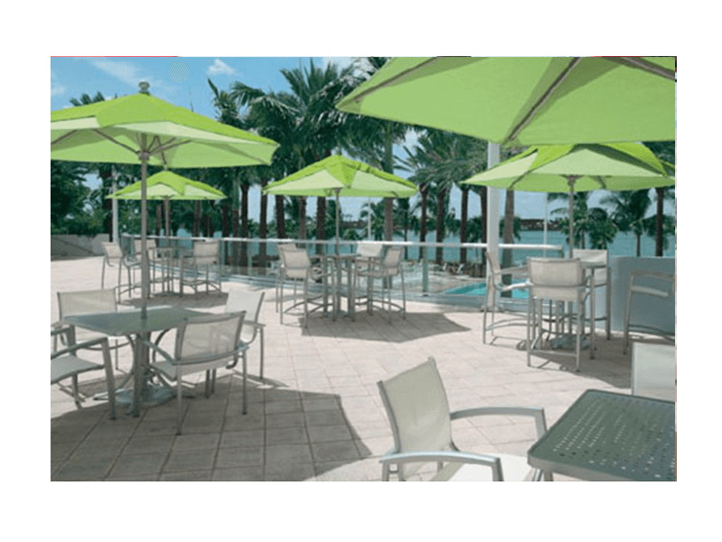 Tropitone chairs and tables with green umbrellas