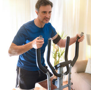 Man using an elliptical at home