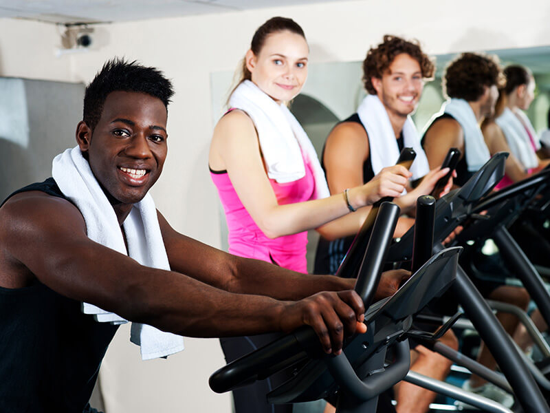Men and women working out on ellipticals