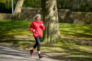 woman in red jacket running in park